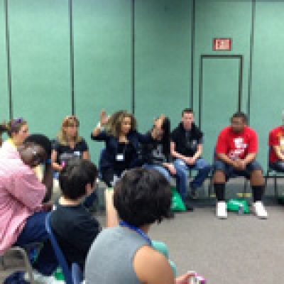 Workshop participants seated in a circle with Ereka Howard